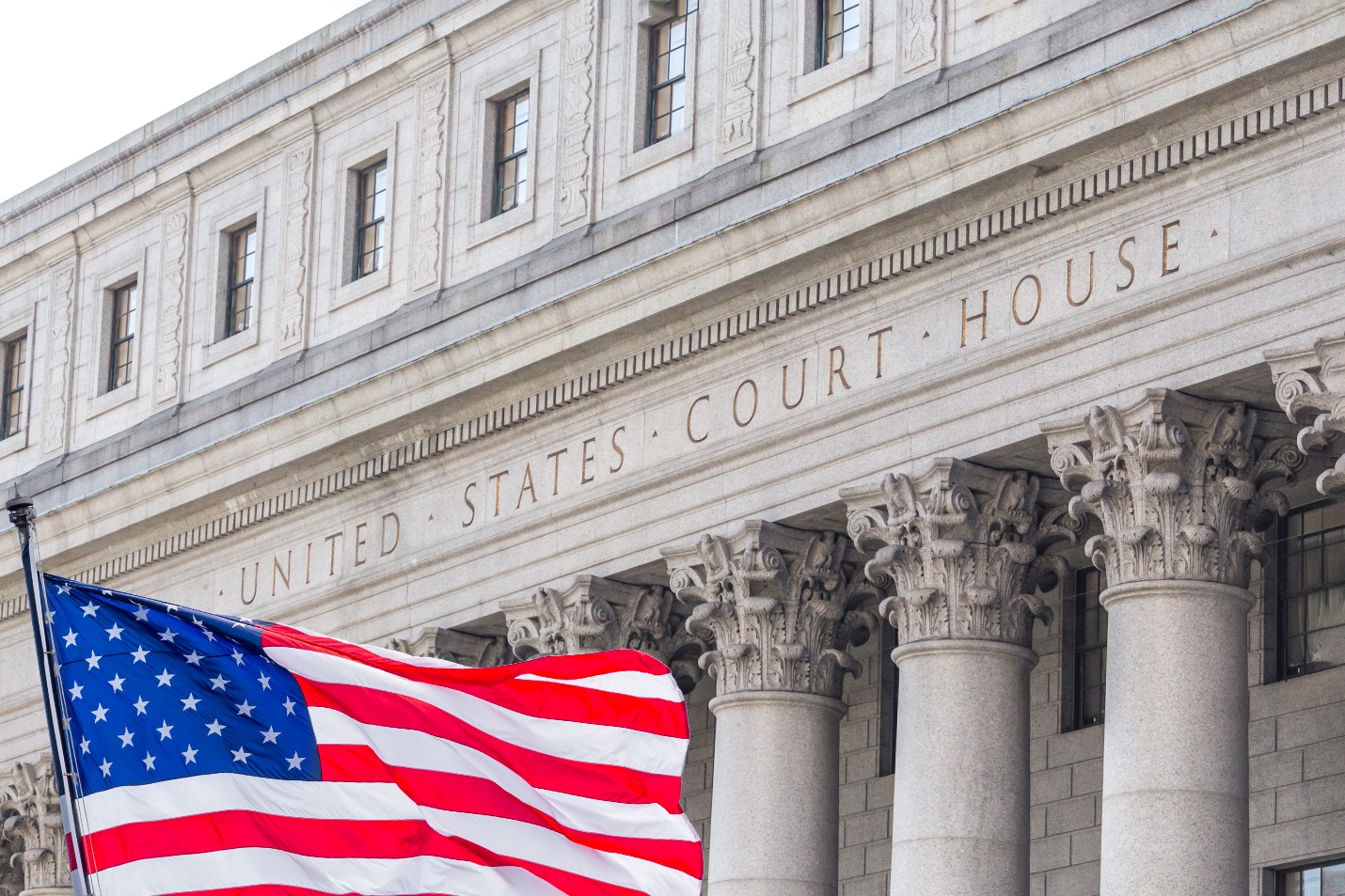 A flag flying in front of a courthouse

Description automatically generated